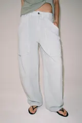 Pantalón cargo de tiro medio, confeccionado en mezcla de algodón y lino, con perneras anchas, bolsillos de plastrón en el delantero y cierre frontal con cremallera y botón.