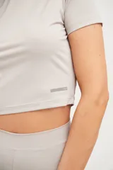 Remera corta de lycra color visón, de corte ajustado y mangas cortas.