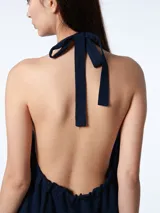 Vestido corto azul marino de tencel con corte evasé, cuello halter con lazo ajustable y espalda descubierta.