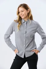 Camisa de manga larga con diseño de rayas verticales, confeccionada en mezcla de algodón, nylon y spandex. Cuenta con cuello camisero clásico y cierre frontal abotonado.