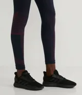 Legging deportiva de tiro alto confeccionada en tejido de poliamida sin costuras. Presenta un diseño ajustado al cuerpo con detalles geométricos contrastantes en la parte inferior de las piernas.