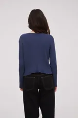 Saco de punto acanalado color azul, con escote profundo en V y cierre frontal mediante lazo para anudar. Presenta mangas largas y diseño holgado.