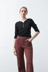 Pantalón ancho de tiro alto, color negro, con pretina y doble botón metalizado.