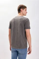 Remera gris de manga corta con efecto lavado y bordado de una mano en el pecho.