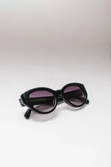 Lentes de sol ovalados con montura de acetato color naranja y lentes marrones degradados. Ofrecen protección UVA/UVB.