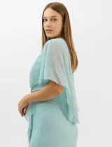 Vestido midi de tejido metalizado color turquesa, con sobrecapa de tul liviano sobre los hombros, detalle de pedrería en la cintura, volado lateral y tajo frontal.