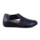 Zapato casual Korium Confort modelo Jessie, de color negro con acabado metalizado y sutil brillo. Presenta diseño cerrado con perforaciones decorativas en la parte superior y laterales elásticos para mayor comodidad.