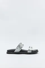 Sandalias plateadas con doble tira ancha y microtachas metálicas.