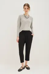 Pantalon estilo babucha color mostaza, con cintura elástica y cordón de ajuste, bolsillos diagonales frontales y terminaciones ajustadas en los tobillos.