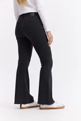 Jean de corte oxford con tiro alto, ajustado hasta la rodilla y con apertura amplia en el bajo. Confeccionado en denim negro con cierre frontal de botón y cremallera.