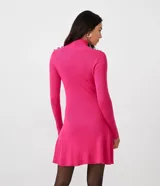 Vestido corto de punto acanalado negro, con cuello alto, mangas largas y falda acampanada. Presenta detalle de botones dorados en los hombros.