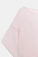 Camisa amplia de color rosado, con diseño estilo capa, cuello redondo y manga corta amplia. Cuenta con un bajo ajustable mediante lazada lateral.