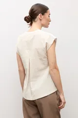 Remera blanca sin mangas con escote en V, detalles de botones en el lateral y espalda de tejido de punto en tono tostado.