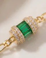 Gargantilla de plata 925 con baño de oro, compuesta por una cadena de eslabones y tres dijes cilíndricos decorados con circonias brillantes y piedras rectangulares en tonos verde y fucsia.