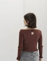 Remera marrón acanalada de manga larga con escote redondo y terminaciones con volados.