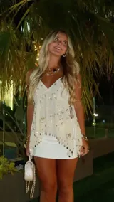 Blusa blanca con escote en V, breteles finos y apliques de lentejuelas y mostacillas.