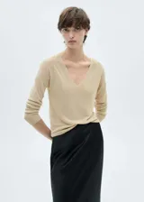 Jersey de punto fino con acabado de lúrex, color beige dorado, con cuello en V y mangas largas de corte recto.