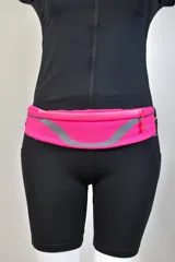Riñonera deportiva color fucsia con detalles reflectantes grises y cierre superior con cremallera.