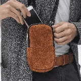 Riñonera porta celular de cuero vacuno color marrón, con correa de cinta ajustable y forro interior de tela.