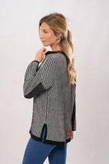 Sweater de punto con cuello redondo y mangas largas. Diseño a rayas verticales en tonos gris y negro.