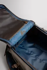 Maleta deportiva de tejido técnico color verde oliva/marrón oscuro, con detalles en marrón claro. Cuenta con asas de mano, asas de hombro ajustables y múltiples compartimentos con cierre de cremallera y hebilla de liberación rápida.