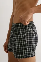 Pack de dos calzoncillos tipo boxer de tela suave, con cintura elástica y bragueta de botones. Ambos presentan diseños a cuadros en tonos blanco y negro.
