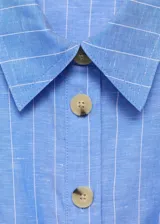 Vestido midi sin mangas confeccionado en mezcla de algodón y lino. Presenta cuello camisero, cierre frontal con botones y cinturón ajustable con hebilla a tono. Diseño de corte evasé con estampado de rayas verticales.