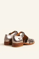 Sandalia cerrada tipo pescador de cuero negro charol, con tira en T y hebilla ajustable en el tobillo. Posee suela y taco bajo de madera.