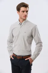 Camisa celeste de manga larga confeccionada en algodón, con cuello camisero, cierre frontal de botones, bolsillo en el pecho y diseño de cuadros sutiles.