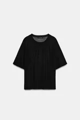 Top de punto fino color negro, de cuello redondo y mangas cortas holgadas.