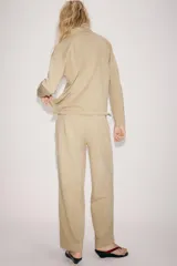 Pantalón balloon de tiro alto confeccionado en algodón, con cintura elástica ajustable mediante cordones tono sobre tono y bolsillos en el delantero.