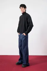 Buzo negro de cuello alto con detalle de la palabra "BESTIA" bordada en el puño.