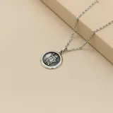 Collar de cadena de eslabones finos con dije circular de medalla religiosa de San Expedito, confeccionado en plata 925 con acabado envejecido.