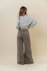 Pantalón de denim color marrón, de tiro medio-alto y calce wide leg con pierna amplia.