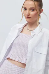 Crop top cuadrillé sin mangas con volados en la cintura.