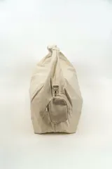 Bolso tipo shopper de nylon color beige, con cierre superior y correa de hombro integrada. Incluye un pequeño monedero colgante lateral.