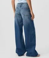Pantalón wide leg de tiro bajo confeccionado en jean de algodón, con diseño de piernas amplias y bolsillos delanteros y traseros.