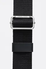 Bolso bandolera de tamaño pequeño en color verde oliva, confeccionado en poliamida con detalles en piel vacuna. Cuenta con asa larga regulable de tejido en color negro, cierre superior con cremallera y logo de la marca estampado en la parte frontal.