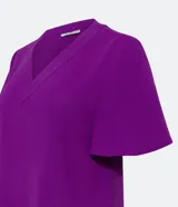 Blusa color violeta con cuello en V, mangas cortas con volados y textura airflow.