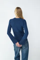 Sweater de punto acanalado color azul oscuro con rayas verticales en azul más claro. Tiene cuello redondo y mangas largas levemente acampanadas.