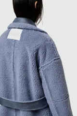 Abrigo largo reversible de ecopiel de oveja color azul con detalles en piel sintética.