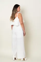 Mono blanco de crepe de seda con corte en la cintura, volados en el busto y espalda y detalle de perlas en los breteles.