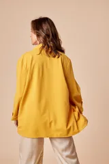 Chaqueta italiana color mostaza, de corte suelto y con bolsillos grandes. Talle equivale entre XL y 1X.