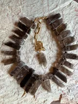 Collar corto con piedras de citrino natural en bruto con corte rectangular en tonos marrones y humo, montadas sobre cadena dorada y eslabones de extensión.