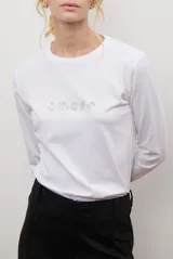 Remera de manga larga color blanco, con cuello redondo y diseño de bordado lineal en el centro del pecho que representa elementos de desayuno.