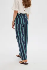 Pantalón jean de tiro alto y corte ancho, con diseño de rayas verticales en tonos azul, verde y marrón.