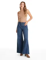 Jean de tiro alto con corte wide leg, confeccionado en denim azul. Presenta cierre frontal con botón, pasacintos y bolsillos delanteros aplicados con pespuntes decorativos.