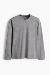 Remera deportiva de manga larga, color gris jaspeado, con cuello redondo y aberturas cortas en el bajo. Confeccionada en tejido funcional DryMove™ que absorbe el sudor.