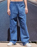 Pantalón de jean azul de corte babucha, tiro medio, con elástico en la cintura, bolsillos delanteros y logo bordado en amarillo en la pierna derecha.