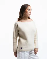 Sweater color crema de lana merino con cuello bote y mangas largas.